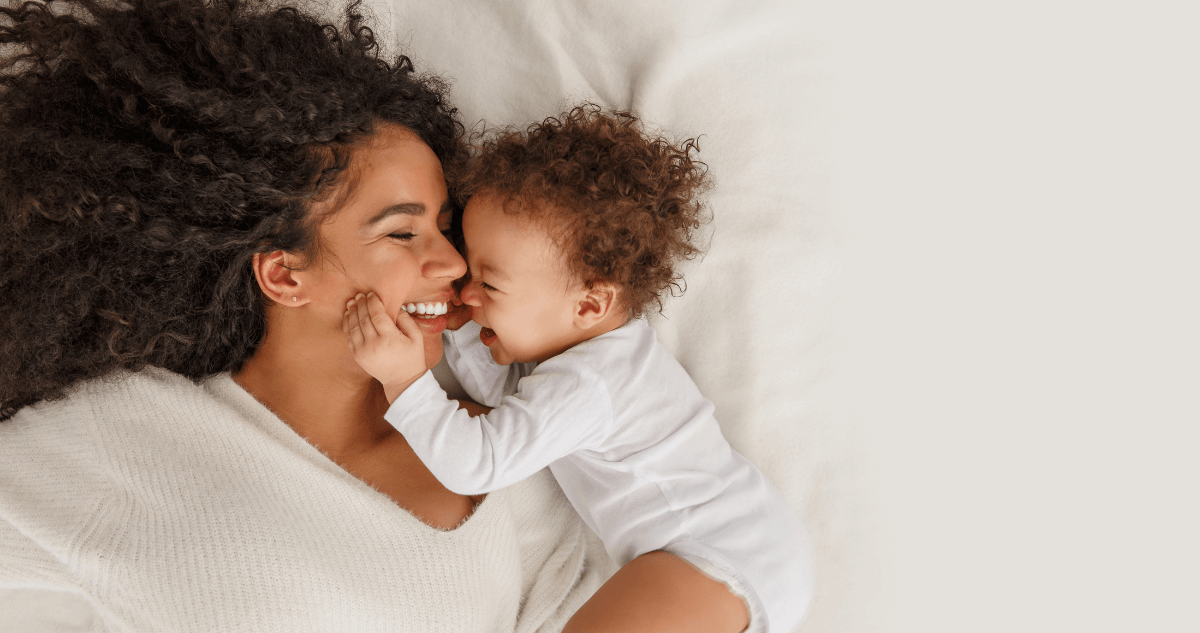 Mother holding her baby in bed