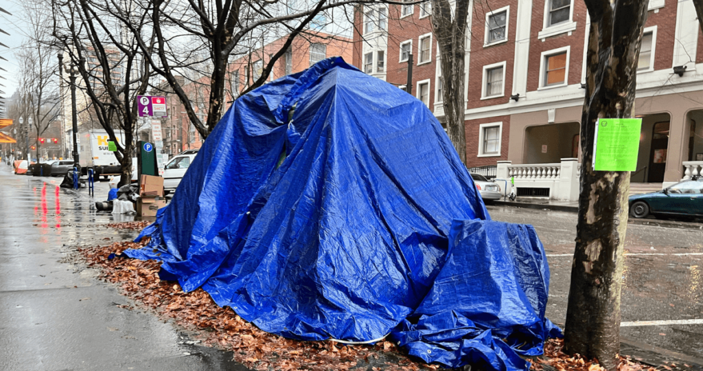 Picture of a tarp covered tent on a sidewalk in Portland.